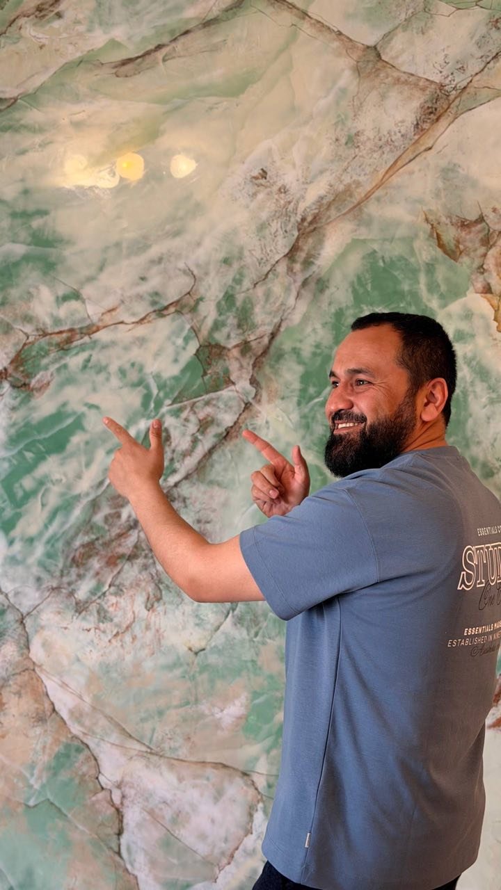Master Sherzod with his signature green onyx marble wall finish